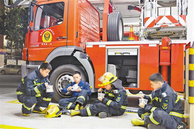 大足區消防救援局南環路消防救援站,完成任務后,消防員們坐地分享“年夜飯”。通訊員 瞿波 攝/視覺重慶