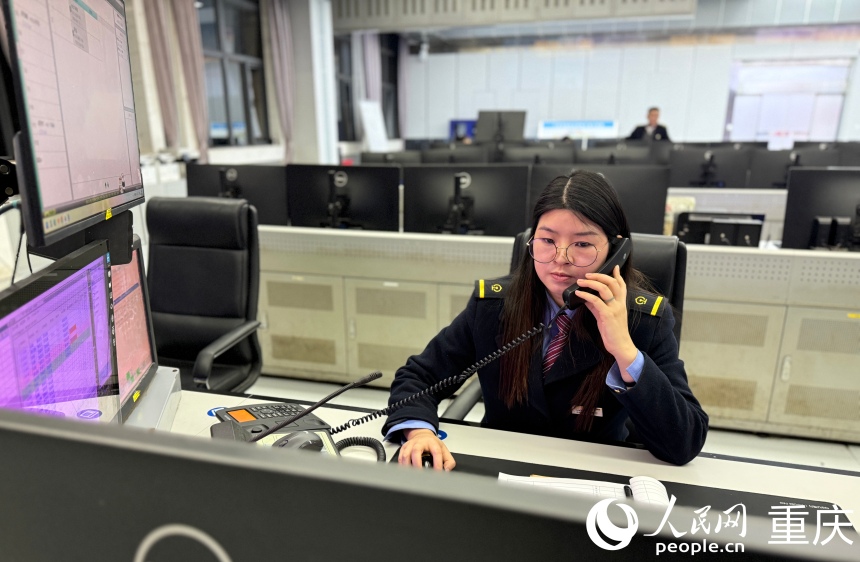 唐巧正在联系列检询问挂头（机车头和车身连接）机车是否就位。人民网记者 胡虹摄
