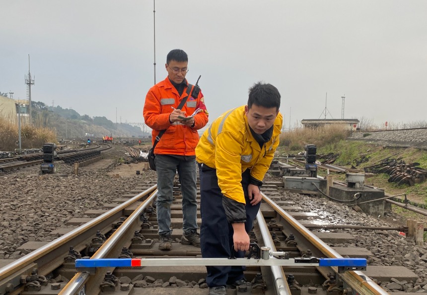 图为唐俊松、石磊对兴隆场编组站道岔进行检查。张凯摄
