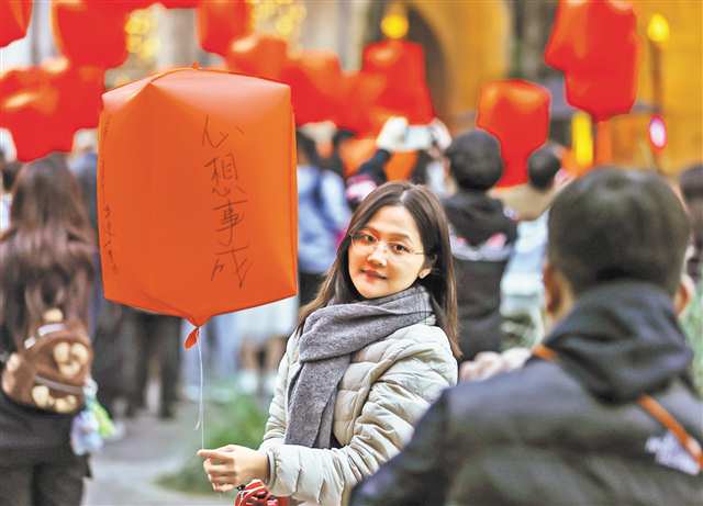 3月3日，渝中区山城巷，领取了电子孔明灯的市民拍照留念。记者 尹诗语 摄/视觉重庆