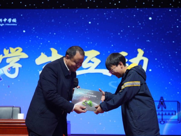 謝更新向學生代表贈送禮物。八中龍興中學供圖