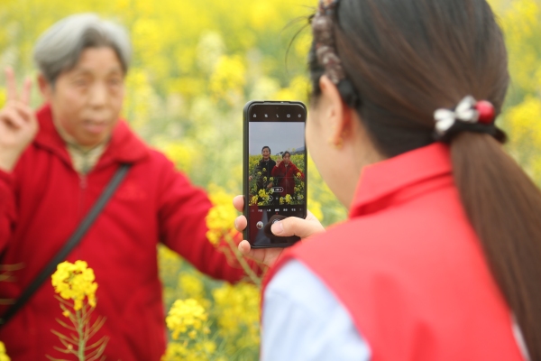 志願者為老人拍照留念。景區供圖