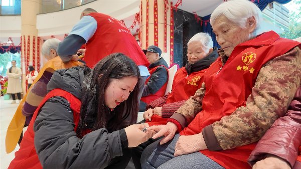 志愿者为老人修建指甲。铜梁区委宣传部供图