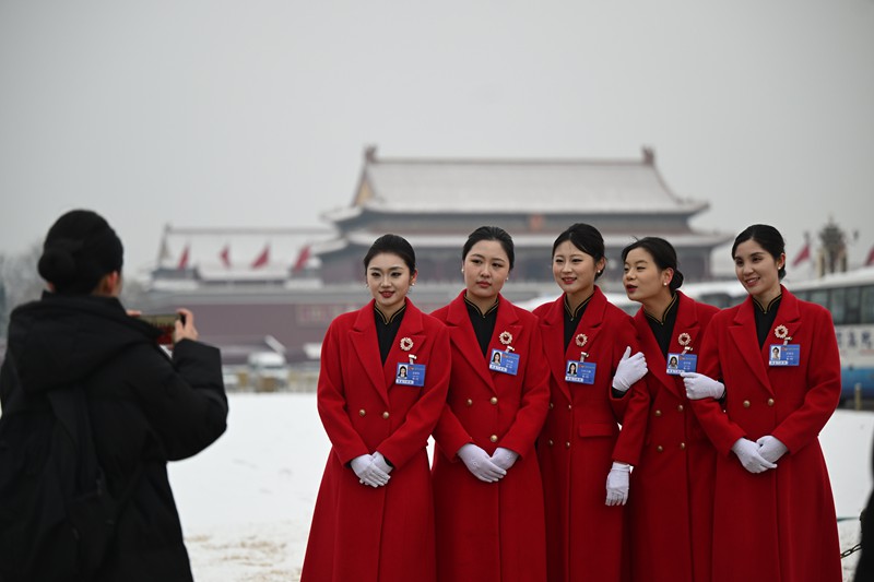 3月5日上午,十四屆全國人大四次會議在人民大會堂開幕。工作間隙,女工作人員們在廣場上留影。記者 蘇思 攝