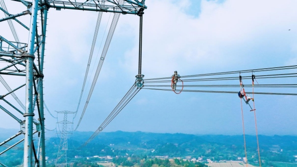 國網重慶超高壓公司帶電作業人員在1000千伏天岳Ⅱ線387號塔帶電處理導線挂點缺陷。余昕垚攝
