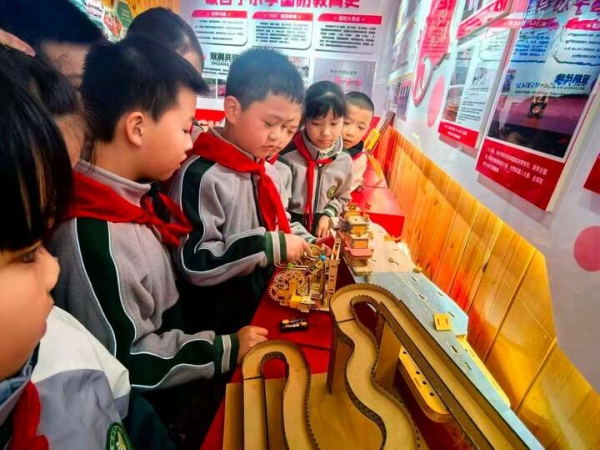 歇台子小学学生走进学校国防教育展厅,在互动体验区参观国防手工作品。 歇台子小学供图
