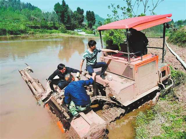 銅梁區白羊鎮座水碾村“三方共耕”基地，村民與機手一起修農機。