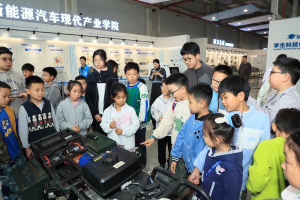 志愿者为孩子们讲解无人驾驶汽车的工作原理。校方供图