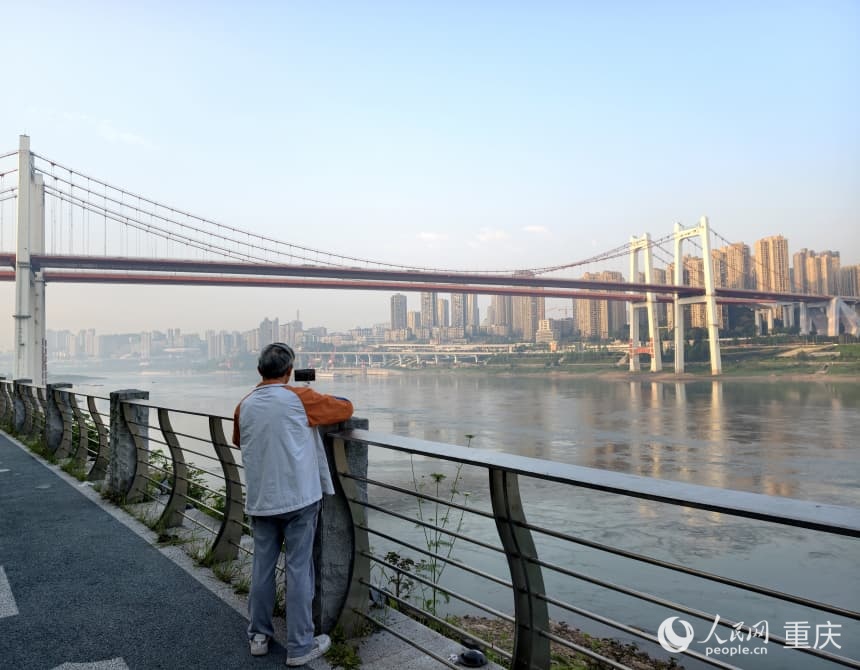 南滨路畔，市民用镜头定格鹅公岩大桥与江面交映的瞬间。人民网 陈琦摄