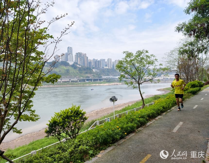 春日的步道上，慢跑的市民正迎着江风向前奔跑。人民网 陈琦摄