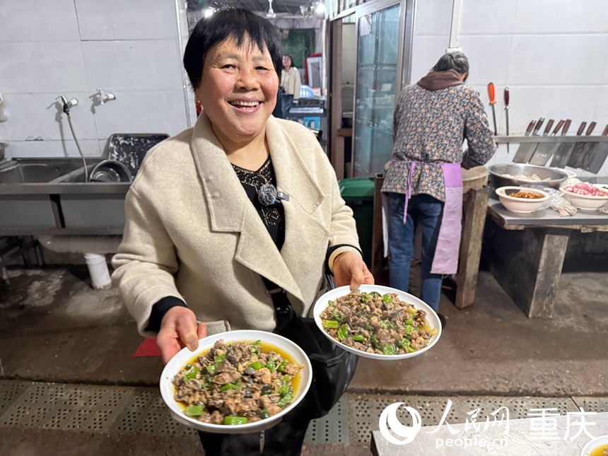 张成书把菜端上桌。人民网记者 胡虹摄