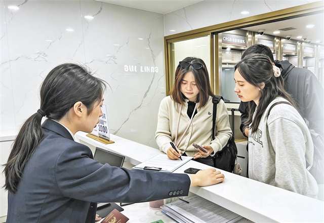 4月20日，解放碑的離境退稅“即買即退”集中退付點，泰國旅客在工作人員幫助下辦理退稅。通訊員 姚慧 攝/視覺重慶