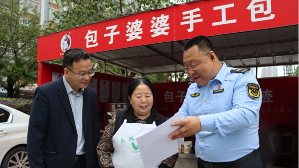 工作人员上门给“包子婆婆”陈淑梅发放商标注册证书。铜梁区融媒体中心供图