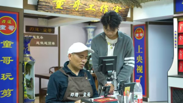 童容教徒弟磨剪刀。革奇摄