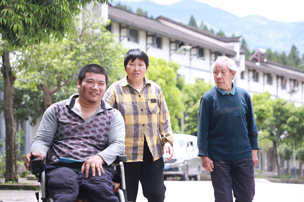 吴祥树照顾高位截瘫的小叔子张玉明。武隆区委宣传部供图