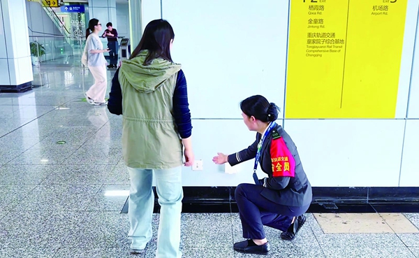 乘客在站台服務人員的指點下，找到充電插座。