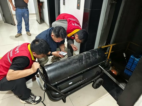 榮昌區“水電氣”紅岩共產黨員服務隊隊員對電梯內部進行烘干。張雄攝