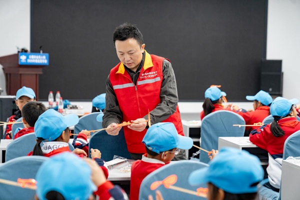 “永翼先鋒”隊員、全國勞動模范何濤指導小學生進行航模組裝。賴小龍攝