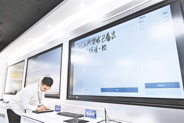 親筆簽展廳，員工展示書寫一段話也能快速精確鑒定。記者 羅斌 攝\視覺重慶