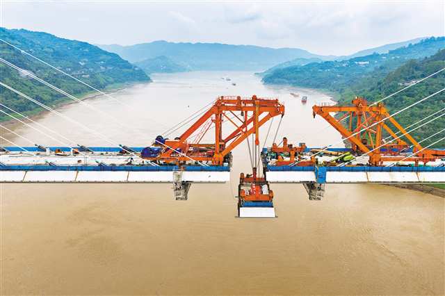 5月26日，渝萬高鐵石沱長江大橋施工現場，最后一段鋼混結合梁即將到達合龍位置（無人機照片）。記者 張春曉 實習生 李子英 攝/視覺重慶