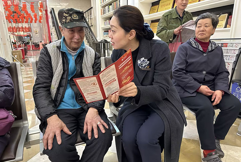 工作人员正在给老年人讲解防诈知识。