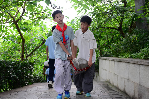 学生搬运中草药种植土壤。学校供图
