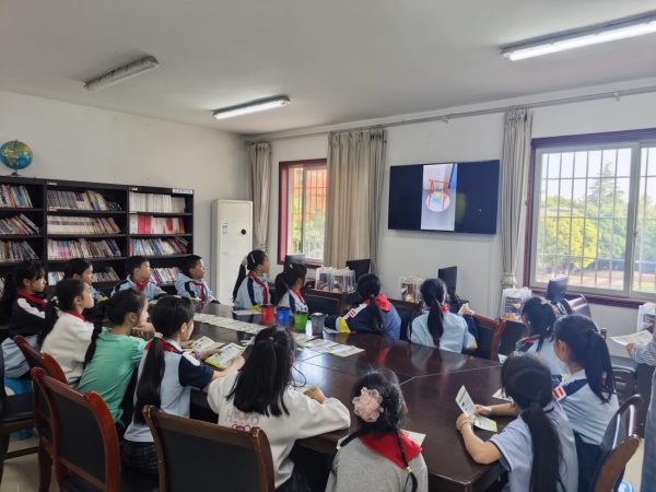 孩子们观看“变废为宝”手工视频。罗菁摄