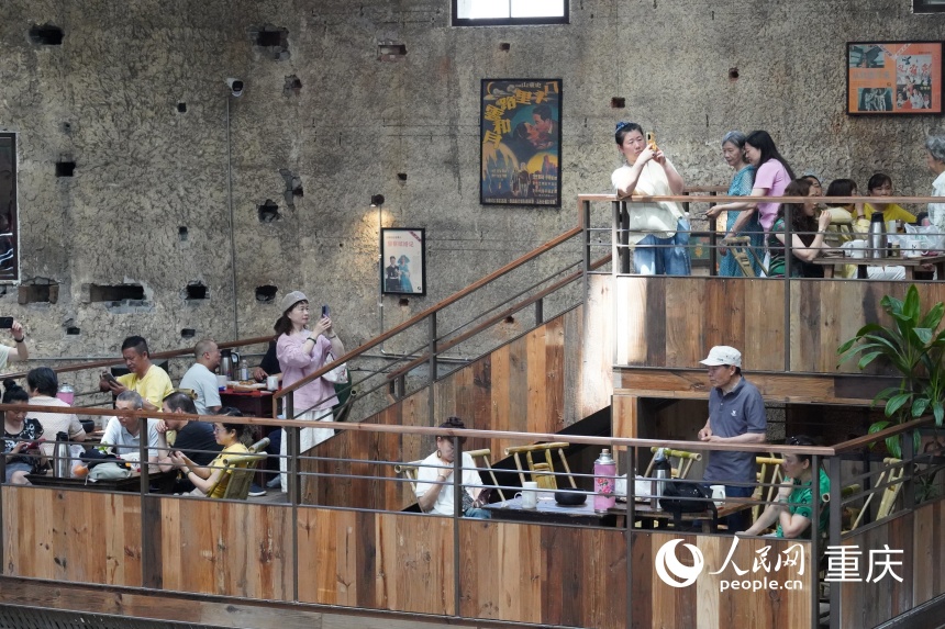 茶馆二楼下沉式卡座区域，市民拍照休憩。人民网记者 冯文彦摄