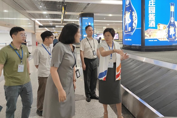专家实地考察行李分拣情况。重庆市人力社保局供图