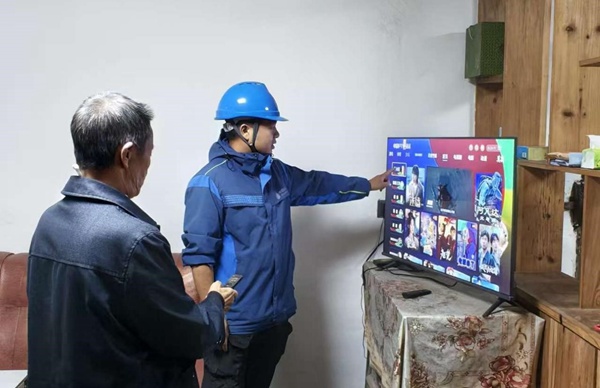 李如军（图右）指导老人操作电视。中国移动重庆公司供图
