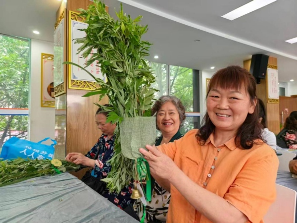 社区居民展示制作的艾草花束。周春英摄