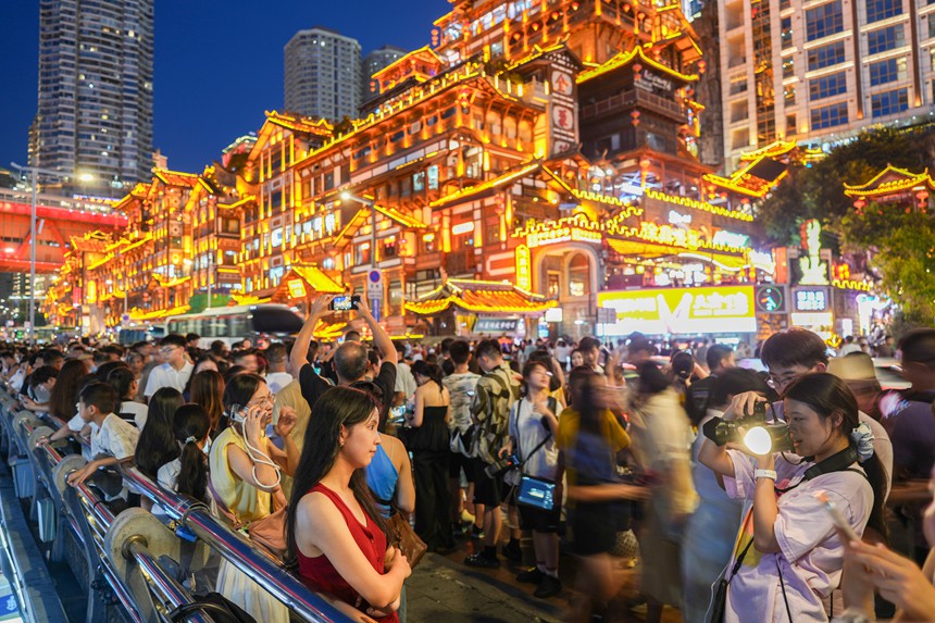 7月13日傍晚，渝中区洪崖洞，游客们争相拍摄打卡。记者 谢智强 摄