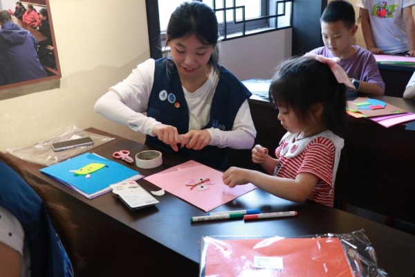 实践团成员带着小朋友做手工。重庆财经学院供图