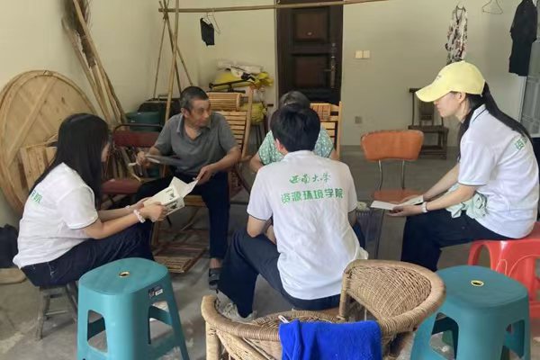 实践团走访农户交流生产难题。学校供图