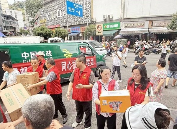 现场志愿者、工作人员接卸物资。重庆邮政供图