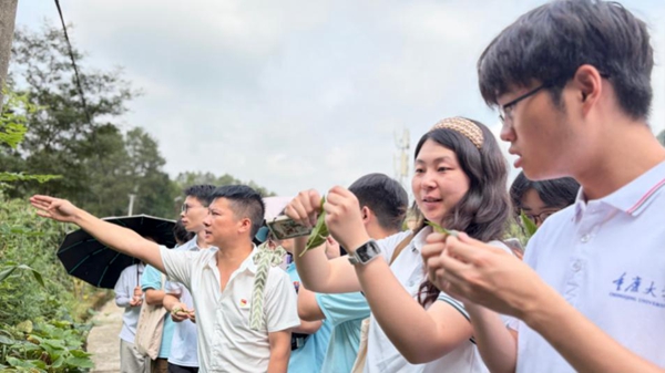 苟坝村党支部书记田云跃带领实践团参观杜仲种植基地。雷佳欣摄