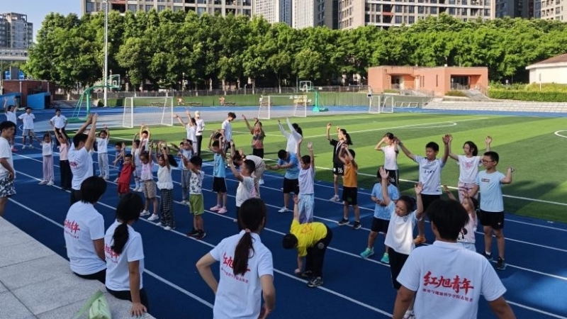 志愿者引导孩子们进行热身运动。重师体育与健康科学学院供图