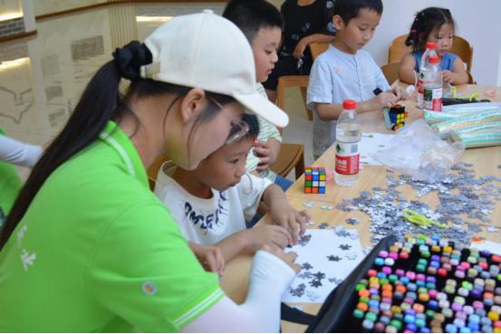 实践团成员与儿童一起拼图。重庆电力高等专科学校供图
