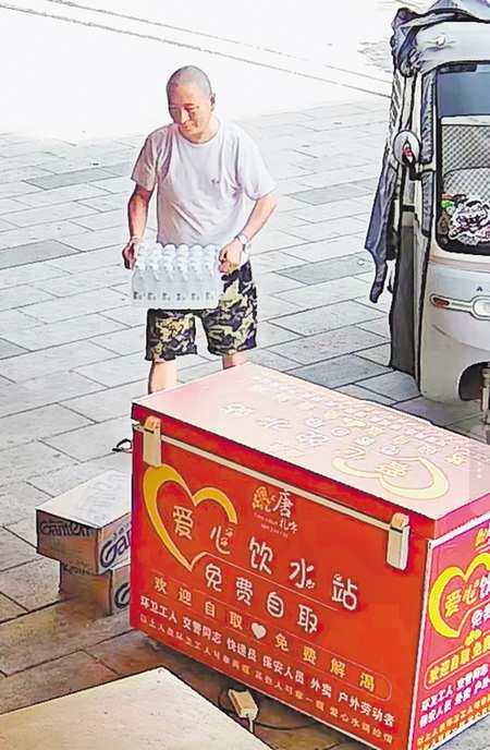 熱心居民曾朋飛正往愛心冰櫃送水。（受訪者供圖）