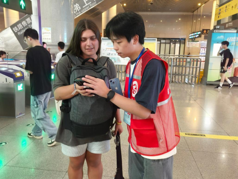 重庆北站国际志愿服务队为外籍旅客提供换乘指引服务。重庆北站供图