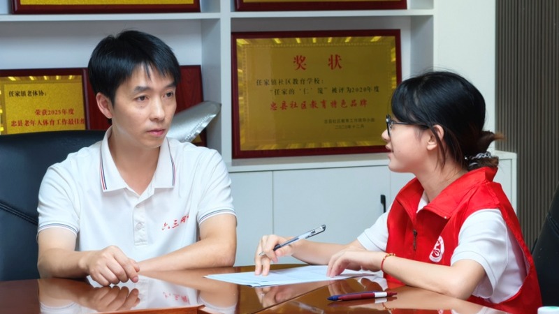 实践团成员与基层干部交流。罗江杰摄