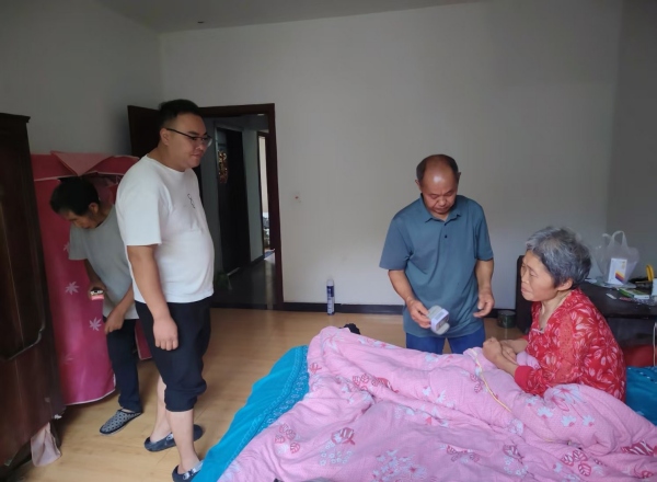 杨建波（左二）带医生给老人看病。武隆区委宣传部供图