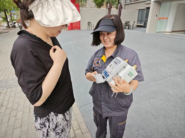 安检员正在为用户讲解气表如何读数。重庆燃气集团供图