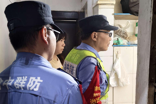 社区工作人员进入厨房查看险情。渝中区融媒体中心供图