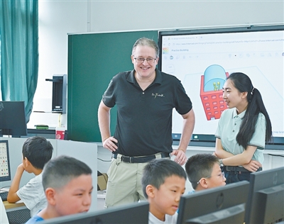 老福（中）在重庆北碚区文星小学指导学生3D建模。龙文泉摄