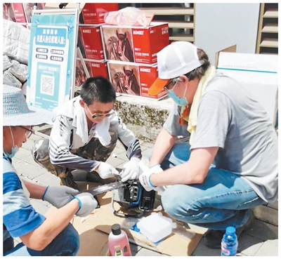 老福（右）在重庆北碚区缙云山集散点组装油锯，同时等待上山救援。受访者供图