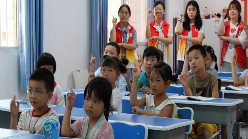 实践团队带领儿童学习《门前有段长征路》手语舞。唐苏川摄