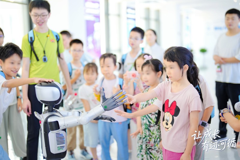 小朋友和机器人互送。招商积余重庆公司供图