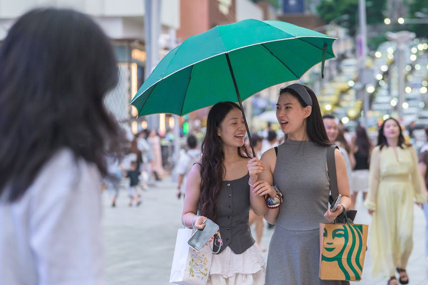 8月29日，兩江新區觀音橋步行街，市民游客撐傘逛街。記者 李雨恆 攝