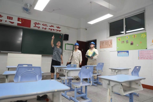 工作人员在北碚区黄桷小学了解教室用电情况。张强 摄